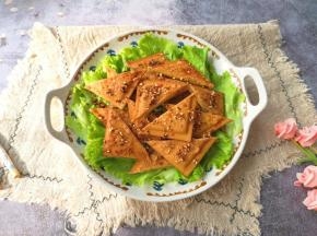 盘子里铺上生菜叶，放上煎好的孜然豆干。