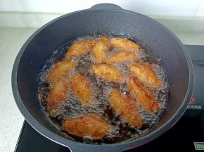 开大火，油温再次升高时放入鸡翅复炸一次。