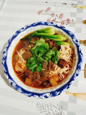 碗中捞两筷子面条，放入适量的面汤，再浇上一大勺红烧牛肉面的卤，最后放上小青菜和葱花，一大碗份量超满足的红烧牛肉面就做好了！开吃吧！