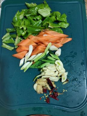 青椒去蒂去籽切成小块，胡萝卜切成片，蒜苗切成段，蒜瓣切成片，生姜切成丝，干辣椒切成段备用！