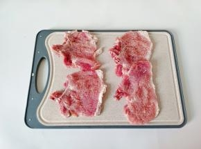 大排用锤子或者刀背捶打大排变薄一点，白色筋的位置分别切两下，这样煮好的大排不会卷起来！