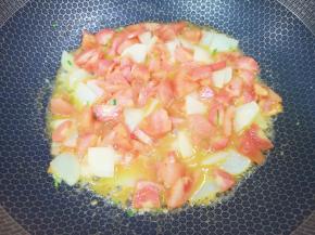 下入西红柿、红萝卜和土豆片，放盐翻炒至出汁。