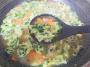 用手将宽面条揪成面片下入锅里。