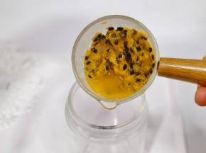 百香果肉挖出来倒入杯中。