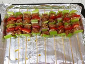 烤盘里铺上锡纸，刷上一层食用油，摆上穿好的肉串。 