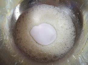 蛋清里面加入几滴白醋，用电动打蛋器低速打发至粗泡状，一次性加入细砂糖和盐。
