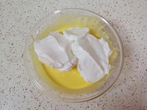 打发好的蛋白取三分之一加入蛋黄糊里面，用硅胶刮刀采用切拌和翻拌的方法混合均匀。 