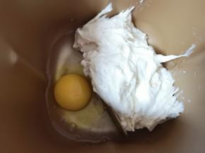 将发酵好的酵头放入面包机桶内，加入纯净水，打入一个鸡蛋。 