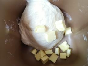 加入黄油，继续选择面包机的“和面”程序，启动揉面15分钟。 