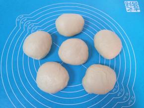 将发酵好的面团从盆里取出拍打排气，分成6份。 