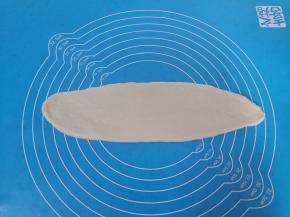 将一份面团擀开成牛舌状，卷起来成长条状，全部完成松弛几分钟。 