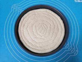 发酵好的面团揉光排气， 擀成和烤盘差不多大小的面片，放入烤盘，用叉子扎上小孔，防止饼皮在烤制的过程中凸起。 