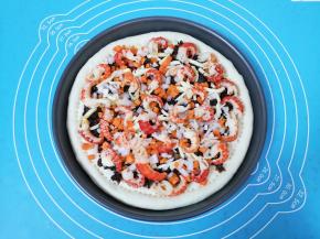 撒上一半洋葱胡萝卜碎，铺上处理好的虾仁，再在虾仁上面撒上剩下的一半洋葱胡萝卜碎。 