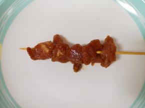 将腌制好的里脊肉用竹签串起来。