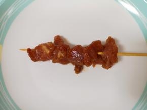将腌制好的里脊肉用竹签串起来。