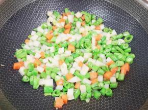 下入土豆、豆角和胡萝卜翻炒至变色。