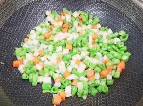 下入土豆、豆角和胡萝卜翻炒至变色。
