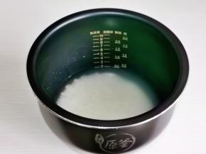 大米淘好后倒入电饭煲内胆中，加入和平时做米饭同样的水量，这款电饭煲2杯米，水量到东北米2的刻度即可。