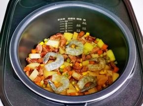 煲仔饭结束后摆入腌制好的虾仁，焖5分钟即可。