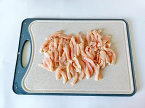 鸡胸肉撕去筋膜，对半切开再切成小条。