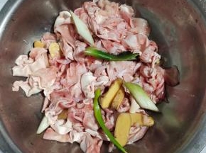 放入适量的料酒，葱段，生姜片抓拌均匀腌制20分钟！去腥增香！