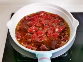 锅中加油，适当多一点，夹入腌制好的牛肉粒。