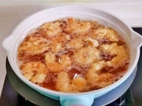 下裹好面糊的虾仁，炸至微黄捞出。