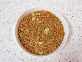 炒米饭放入烤碗里用勺子压平。 