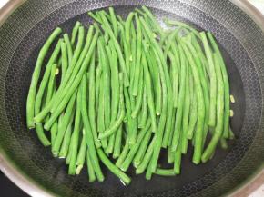 锅里放水烧开，下入豇豆焯水至变色捞出过凉水，控一下水分备用。