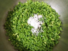 将豇豆碎放入大一点的盆里，放入食用碱搅拌均匀（放食用碱的作用是:为了让豇豆蒸熟以后保持翠绿的颜色，不喜欢可以不放）。 