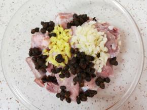 排骨里面加入姜蒜末和豆豉搅拌均匀。 