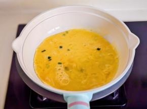 起油锅倒入蛋液，撒葱花。