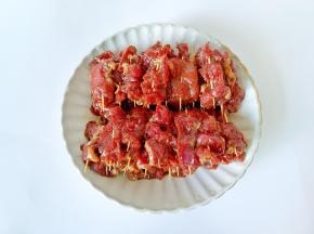 把腌制好的牛肉片用牙签穿起来。