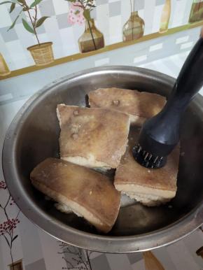 把肉捞出来，稍微晾一下，用扎孔器在猪皮的一面扎些小孔！排除里面多余的油脂！