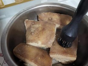 把肉捞出来，稍微晾一下，用扎孔器在猪皮的一面扎些小孔！排除里面多余的油脂！