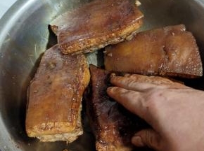 手上倒入适量的红烧酱油，在肉身上均匀的涂抹酱油，肉的每个地方都要涂抹到！