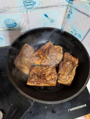 锅里倒入适量的油，油热后转小火，然后把抹上酱油的肉放入油锅里面煎！猪皮朝下放！