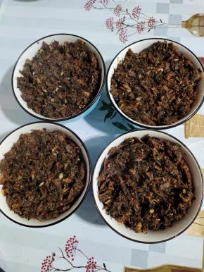 把炒好的梅干菜均匀的铺在碗里的肉上面！把梅干菜铺好后，再用勺子压一压！