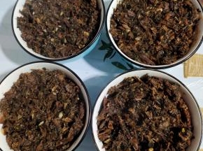把炒好的梅干菜均匀的铺在碗里的肉上面！把梅干菜铺好后，再用勺子压一压！