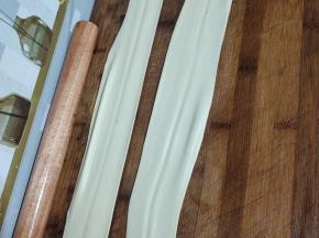 扯住面皮的两头，边均匀的拉扯面皮，边在案板上甩几下，把面皮扯薄！
