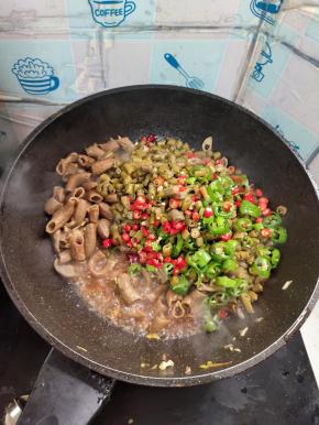 放入酸豆角，青红尖椒翻炒均匀！