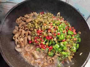 放入酸豆角，青红尖椒翻炒均匀！