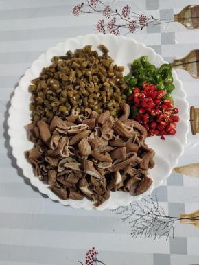 自制酸豆角清洗干净，切成小丁，猪小肠切成小段，青红尖椒切成圈儿备用！