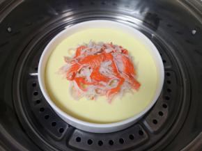 8分钟以后打开锅盖，蛋液已经凝固，放入撕好的蟹棒，继续蒸5分钟。 