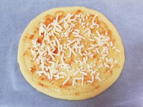 在饼底抹上一大勺番茄酱，撒上少许马苏里拉芝士。 