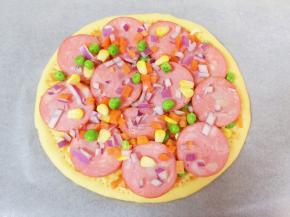 摆上一层香肠，再撒上一层蔬菜粒。