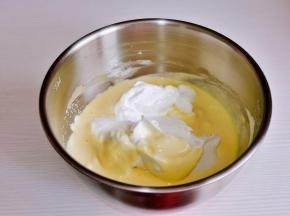 再取三分之一蛋白霜继续翻拌至完全混合。最后将蛋黄糊倒入蛋白霜的器具中翻拌均匀。