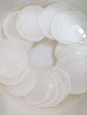 锅里加入适量的水烧开，然后把萝卜片放入焯到稍微透明拿起一块，能弯曲即可出锅
