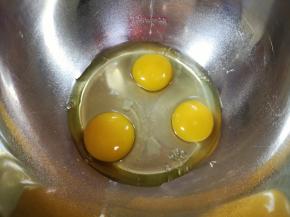 打蛋盆里磕入3个鸡蛋。 