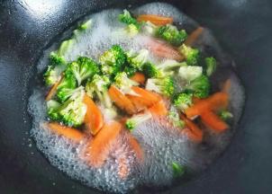 锅中烧开水，加一点点油盐，放入西兰花胡萝卜焯水一分钟捞出。